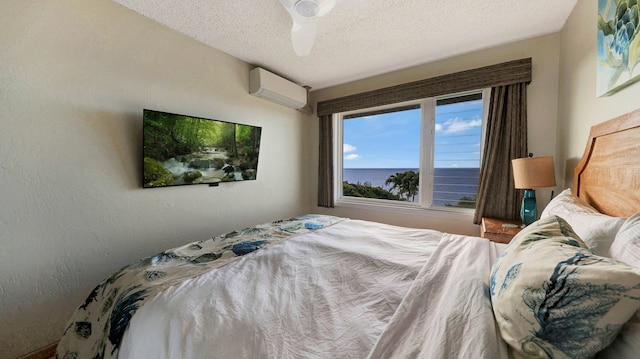 bedroom with a textured ceiling, ceiling fan, and a wall unit AC