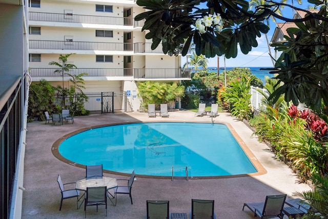 community pool with a patio and fence