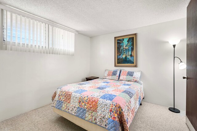 bedroom with sink, a closet, connected bathroom, a textured ceiling, and carpet flooring