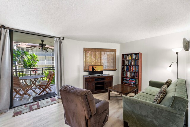 living room with light wood-type flooring, a textured ceiling, and ceiling fan