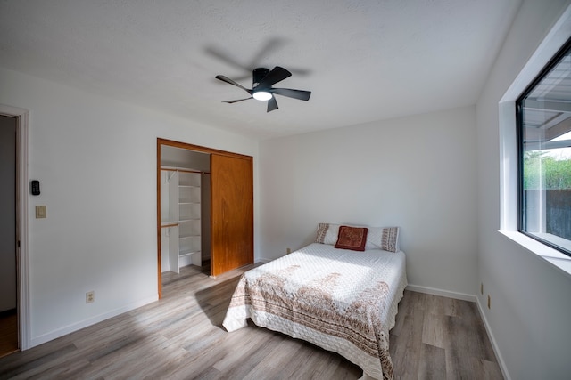 bedroom featuring light wood-type flooring, ceiling fan, and a closet