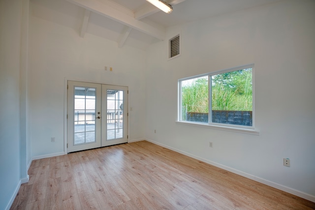 spare room featuring beamed ceiling, light hardwood / wood-style floors, high vaulted ceiling, and french doors