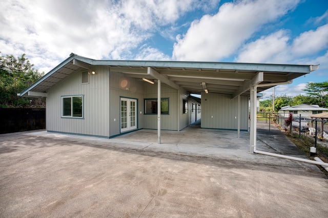 rear view of house featuring french doors and a carport