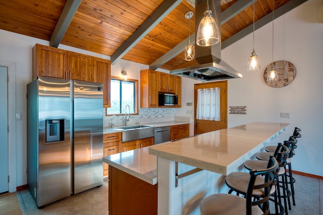 kitchen with stainless steel appliances, kitchen peninsula, hanging light fixtures, sink, and a breakfast bar area