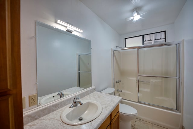 full bathroom with vanity, tile patterned flooring, toilet, combined bath / shower with glass door, and ceiling fan