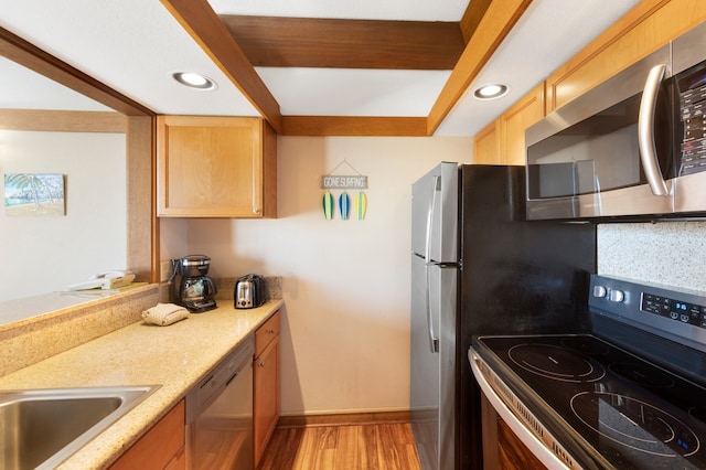 kitchen featuring light hardwood / wood-style floors, backsplash, and stainless steel appliances