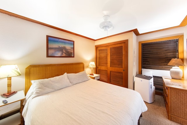 bedroom with ornamental molding, ceiling fan, carpet flooring, and a closet