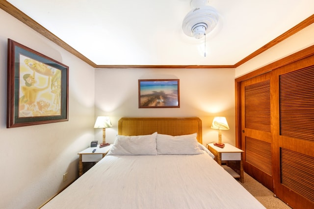 carpeted bedroom featuring ceiling fan, a closet, and ornamental molding