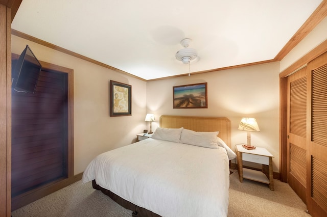 carpeted bedroom featuring ceiling fan, a closet, and ornamental molding