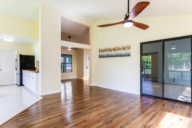 unfurnished living room featuring ceiling fan, hardwood / wood-style floors, and high vaulted ceiling