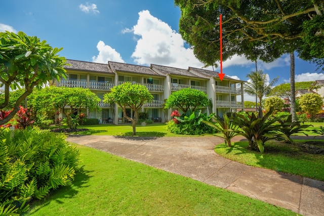 view of front facade with a balcony and a front yard