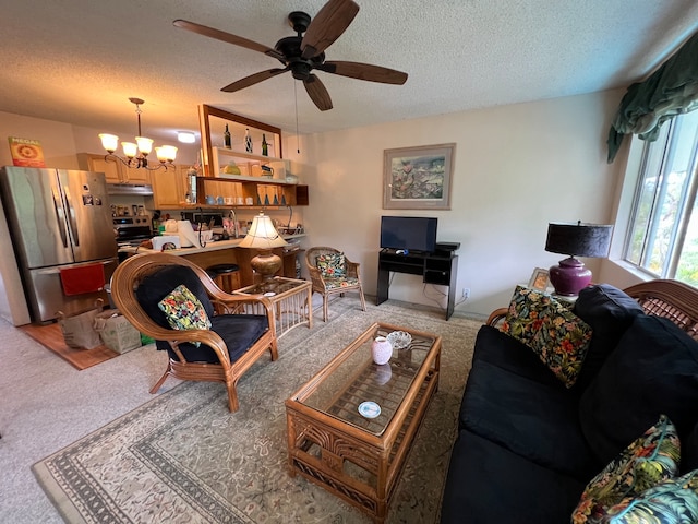 carpeted living room with a textured ceiling and ceiling fan with notable chandelier