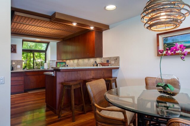 dining space featuring dark wood-type flooring and a notable chandelier