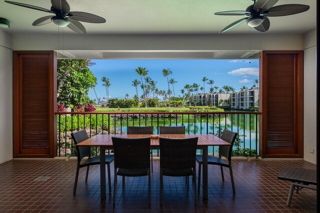 dining room with a water view and ceiling fan