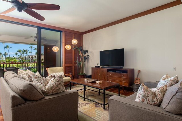 living room featuring hardwood / wood-style flooring, ceiling fan, and crown molding