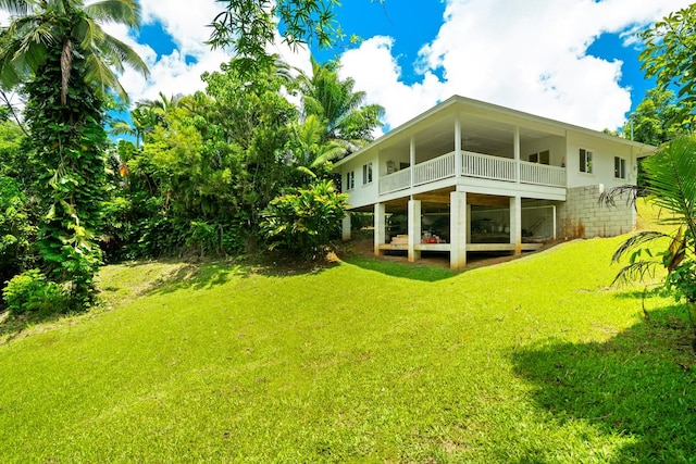 rear view of property with a lawn and a balcony