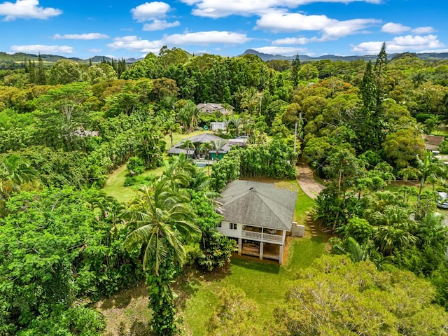 birds eye view of property featuring a mountain view and a wooded view