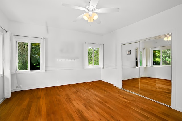 unfurnished room featuring a ceiling fan, baseboards, and wood finished floors