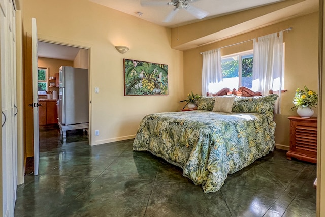 bedroom with ceiling fan, dark tile patterned floors, and stainless steel fridge