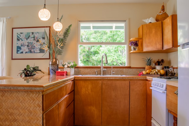 kitchen featuring sink, decorative light fixtures, and white range oven