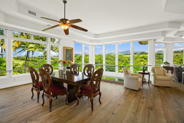 sunroom / solarium featuring ceiling fan, a tray ceiling, and plenty of natural light