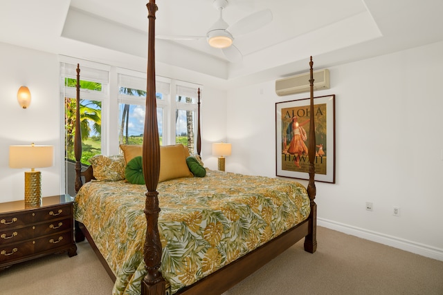 bedroom with ceiling fan, multiple windows, carpet floors, and a tray ceiling