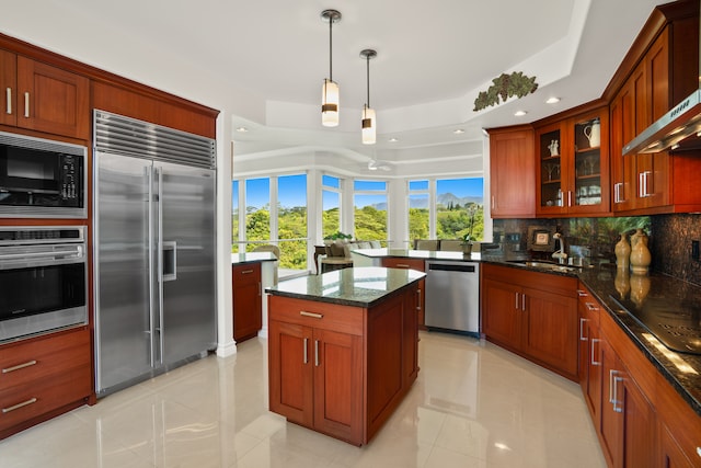 kitchen featuring light tile patterned flooring, tasteful backsplash, black appliances, a raised ceiling, and a center island