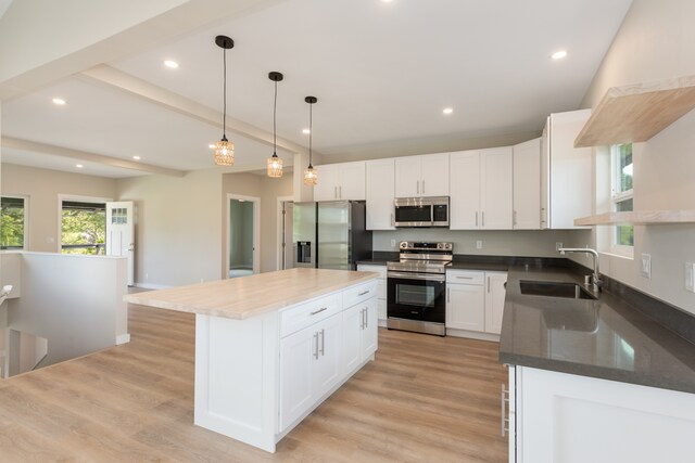 kitchen featuring a center island, sink, light hardwood / wood-style floors, white cabinetry, and stainless steel appliances