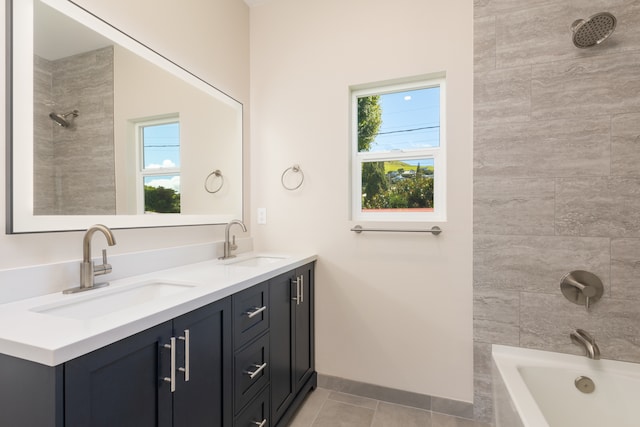 bathroom with tile patterned floors, double sink vanity, and tiled shower / bath