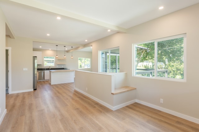 unfurnished living room with sink and light hardwood / wood-style flooring