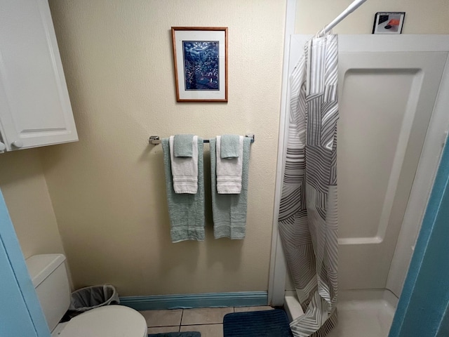 full bath with baseboards, a stall shower, toilet, and tile patterned floors