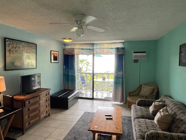 living area with light tile patterned floors, an AC wall unit, a textured ceiling, and ceiling fan