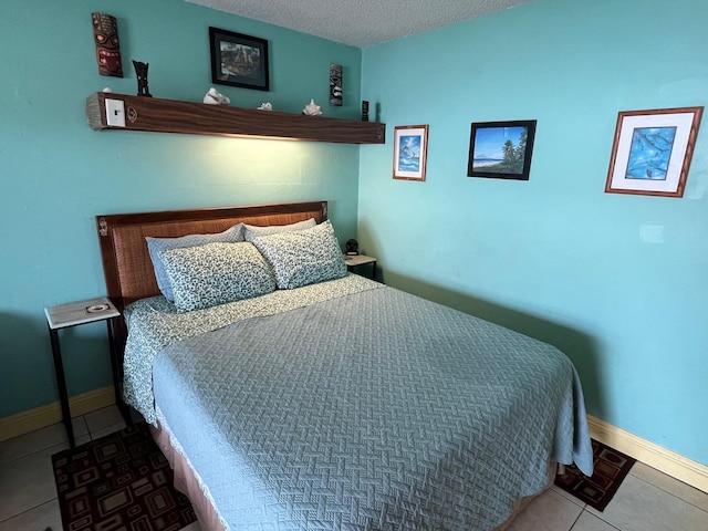 tiled bedroom with baseboards and a textured ceiling