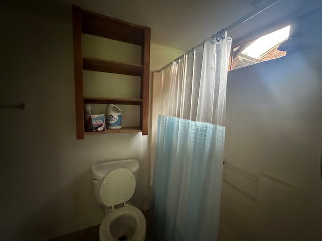 bathroom featuring curtained shower and toilet