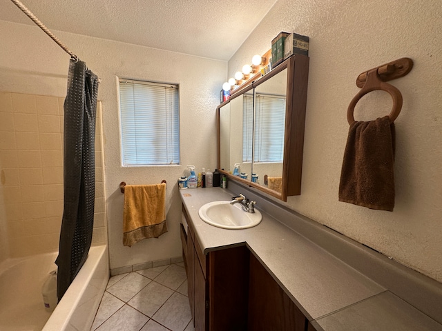 bathroom featuring vanity, shower / bath combo with shower curtain, tile patterned flooring, and a textured ceiling