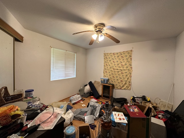 miscellaneous room with a textured ceiling and ceiling fan