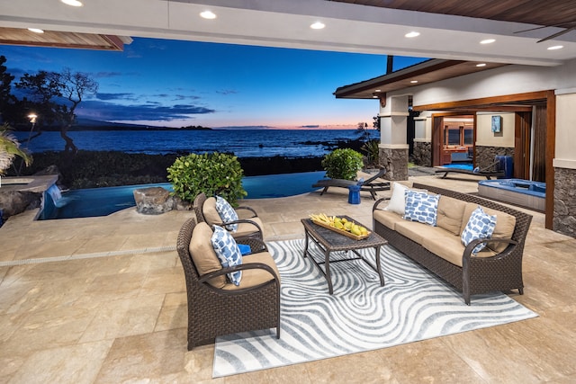 patio terrace at dusk with a water view and an outdoor living space