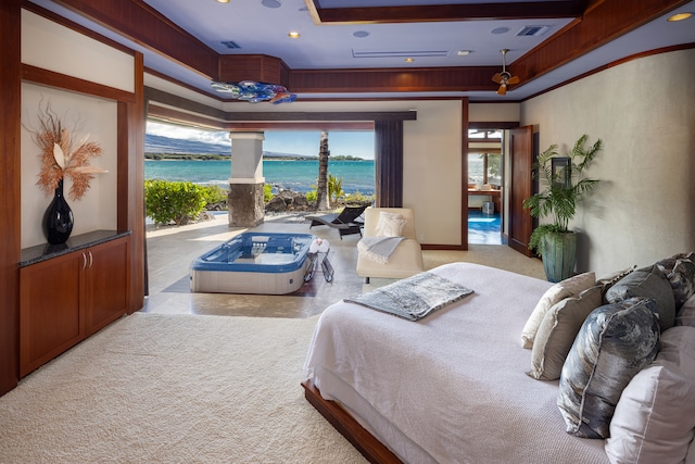 carpeted bedroom featuring a raised ceiling and a water view