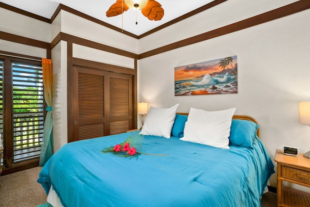 carpeted bedroom featuring ceiling fan, ornamental molding, and a closet