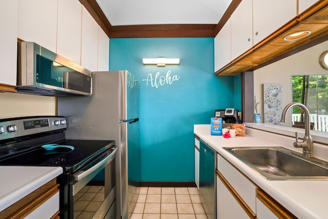 kitchen with light tile patterned flooring, appliances with stainless steel finishes, white cabinetry, and sink