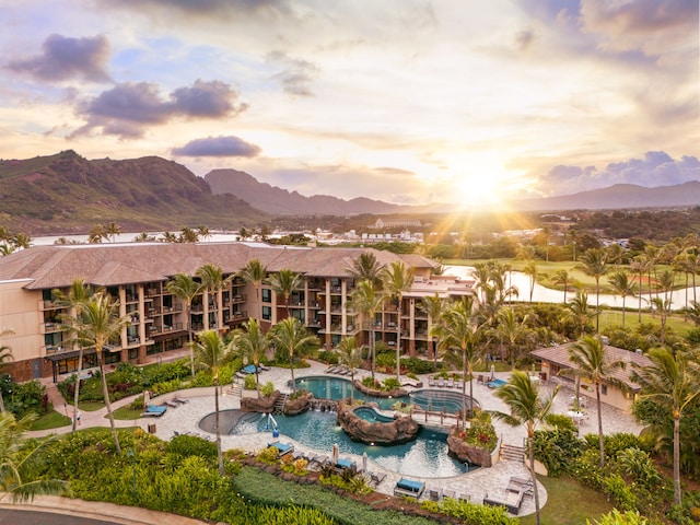 view of property's community with a patio area, a pool, and a mountain view