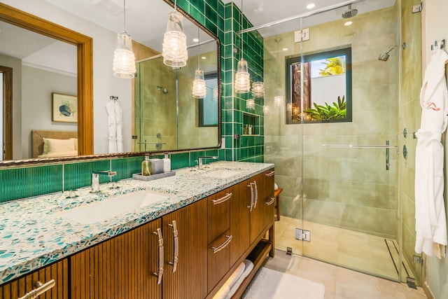 bathroom featuring tile patterned flooring, a shower with shower door, and vanity