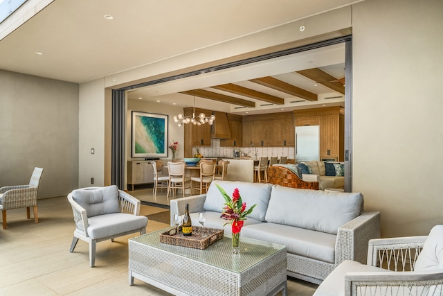 tiled living room with beam ceiling and a chandelier