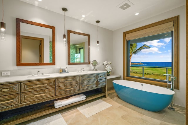 bathroom with vanity, a washtub, and tile patterned floors