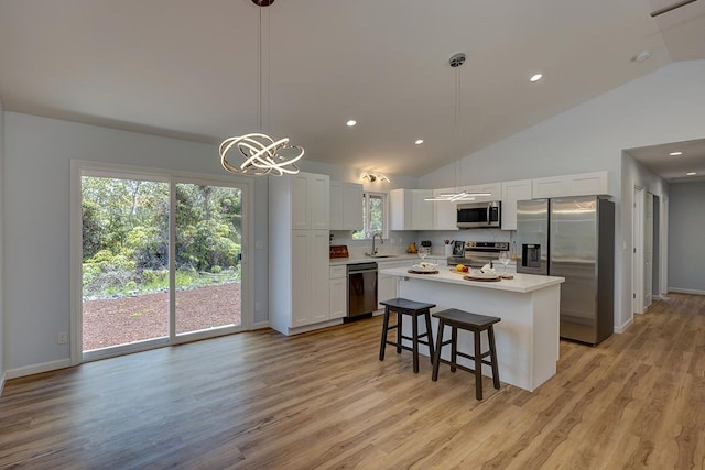 kitchen featuring a sink, a kitchen island, white cabinetry, appliances with stainless steel finishes, and light countertops