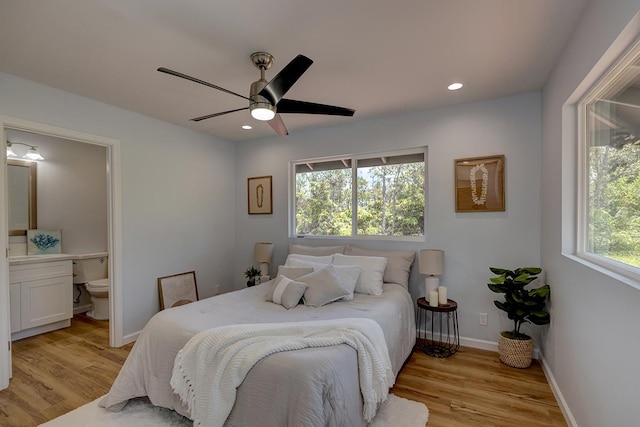 bedroom featuring recessed lighting, baseboards, light wood-style floors, and ensuite bath