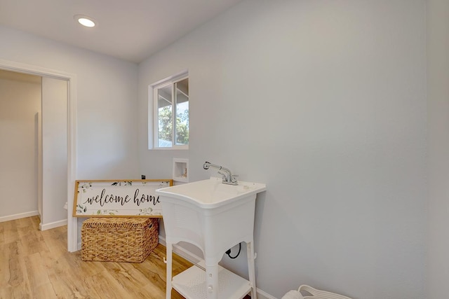 bathroom with recessed lighting, baseboards, wood finished floors, and a sink