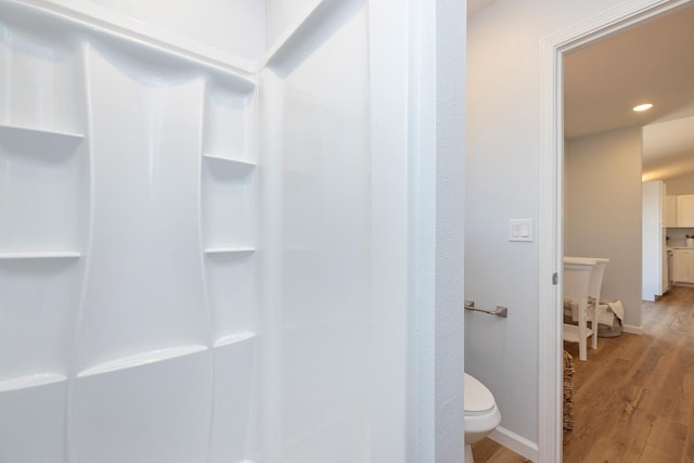 bathroom featuring walk in shower, baseboards, toilet, recessed lighting, and wood finished floors