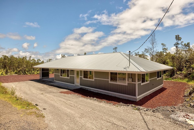 view of front of home featuring driveway and metal roof