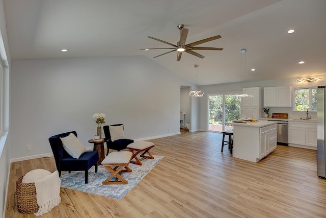 kitchen with a healthy amount of sunlight, a center island, a breakfast bar area, appliances with stainless steel finishes, and white cabinets